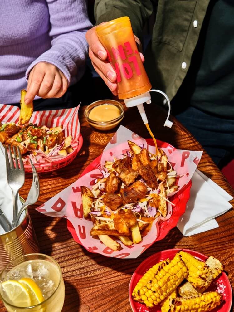Loaded chips and crispy chicken shared at a table